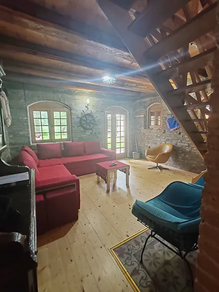 slika dnevne sobe na kojoj je garnitura, ulazna vrata i prozor