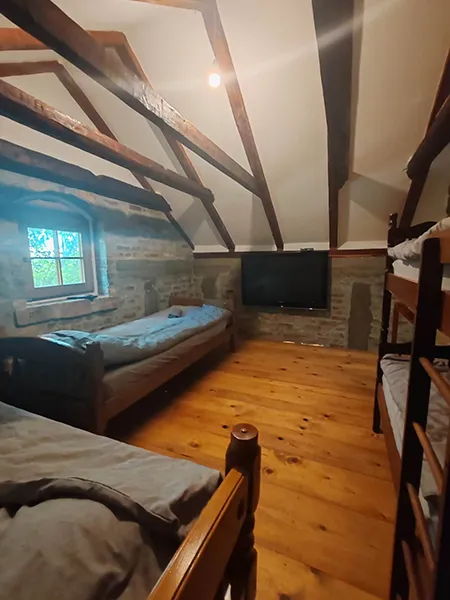 soba na kojoj se vide jedan krevet na sprat, dva kreveta samca , prozor i tv na zidu