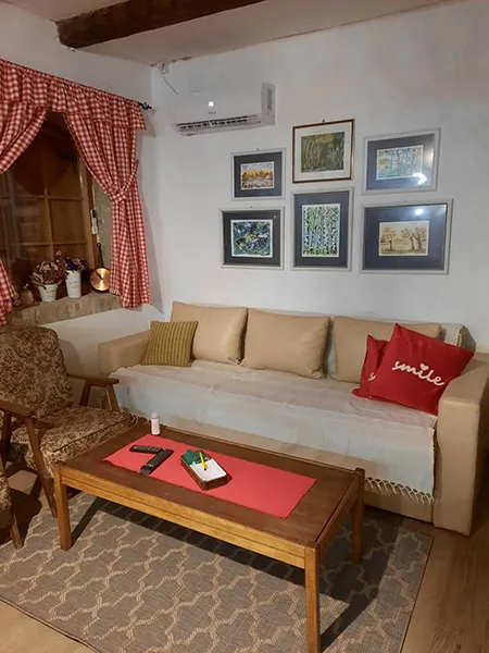 na slici se vide  kauč, fotelja i klub sto i 6 slika na zidu