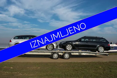 na slici je prikolica sa dva automobila na kojoj piše iznajmljeno