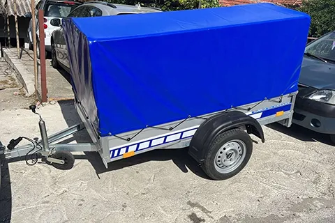 auto-prikolica za prevoz stvari sa plavom ciradom